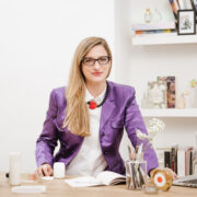 Eleonora Gavino Project Manager settore cosmetico alla scrivania con confezioni di cosmetici e pc